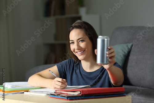 Happy student showing an energy drink can