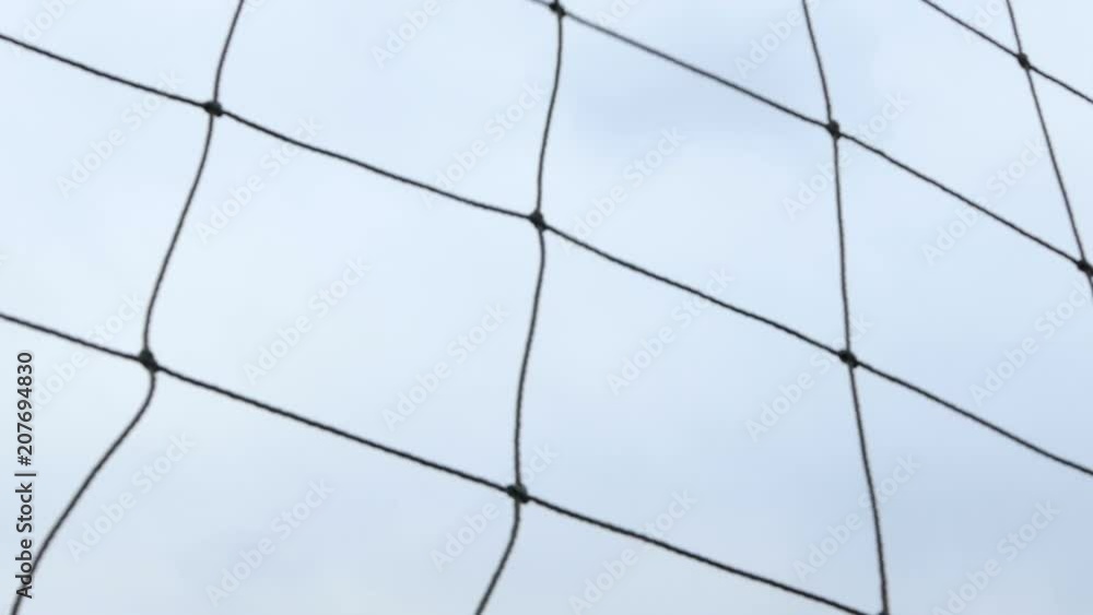 Football ball hits net in slow motion