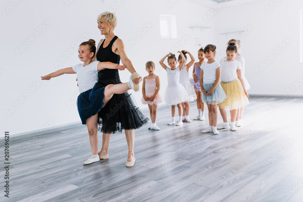 Fototapeta premium Group of beautiful little girls practicing ballet at dancing class.