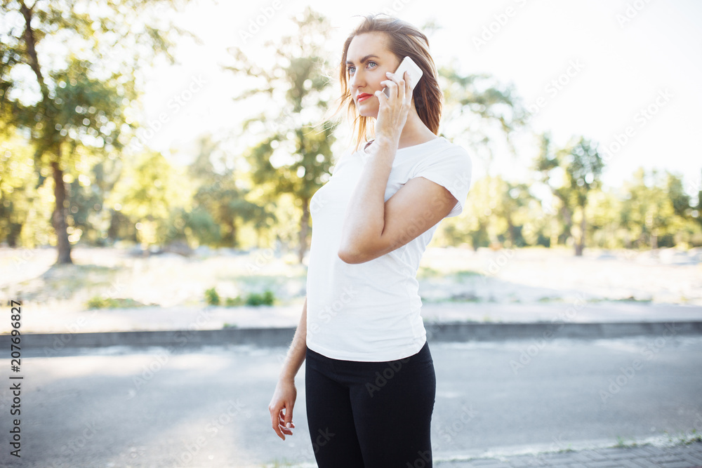 Young athletic girl, cute smiling, and talking on the phone, can be used for advertising, text input Young athletic girl, cute smiling, and talking on the phone, can be used for advertising, text input