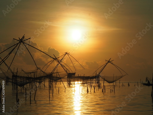 Silhouette thai traditional fishing equipment trap build with bamboo at Pakpra , Patthalung province, Thailand. photo