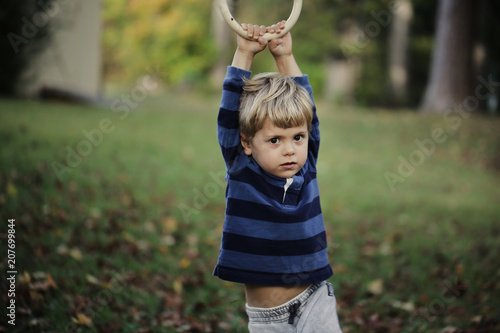 Little boy having fun on outdoor playground. Summer active sport leisure for kids. Kindergarten or school yard. Toddler child activity