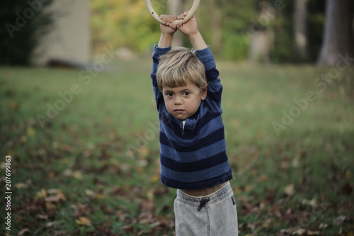 Little boy having fun on outdoor playground. Summer active sport leisure for kids. Kindergarten or school yard. Toddler child activity