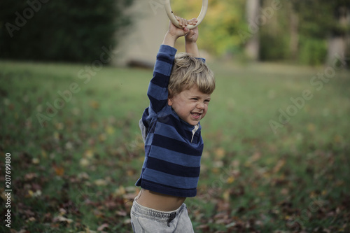Little boy having fun on outdoor playground. Summer active sport leisure for kids. Kindergarten or school yard. Toddler child activity