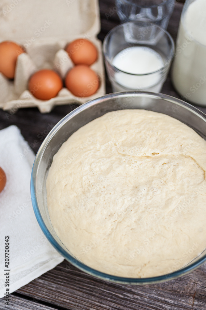Fresh raw dough ready for baking on rustic wooden background Fresh raw dough ready for baking on rustic wooden background