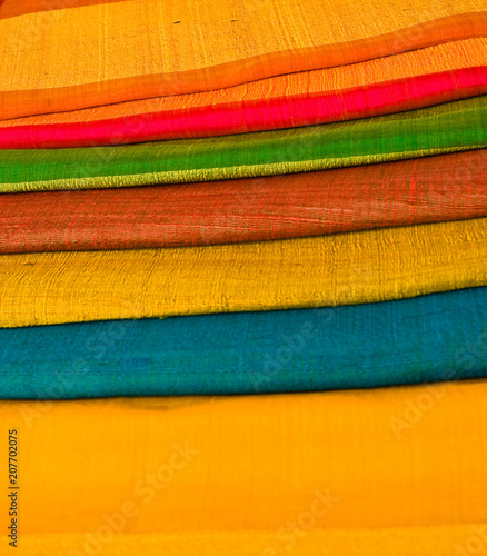 Bright bolts of cloth stacked up in vibrant colors