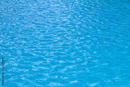 small waves and ripples on the blue water of the swimming pool