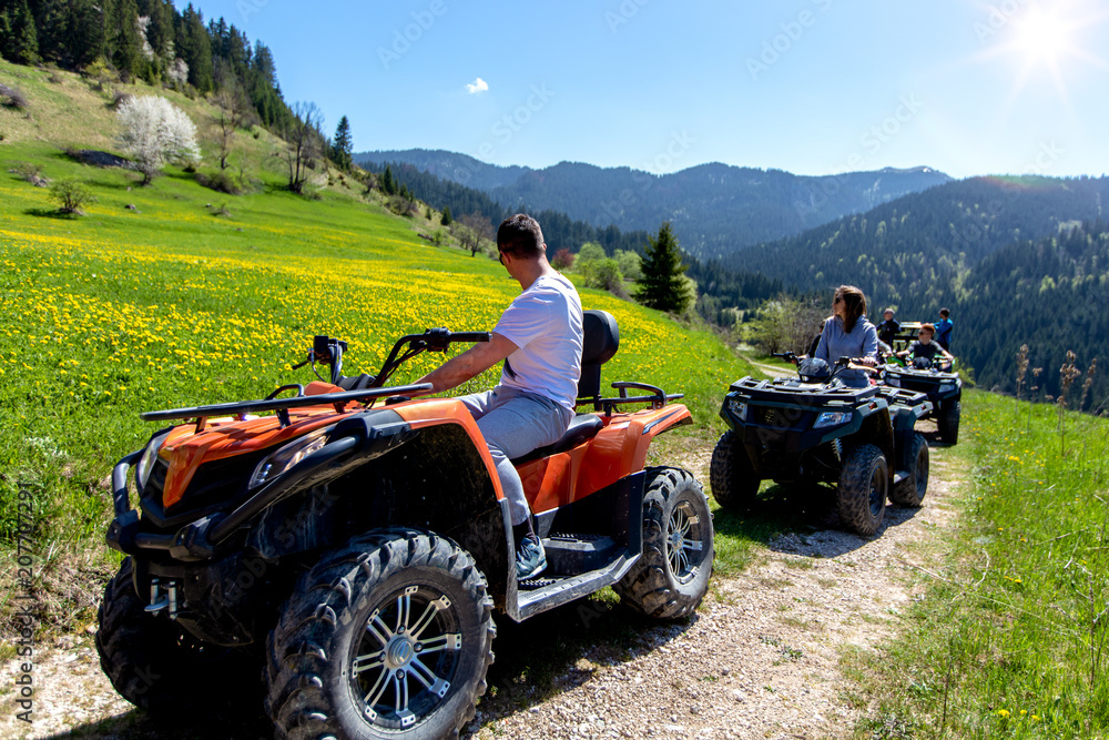 A tour group travels on ATVs and UTVs on the mountains