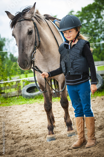 Young horse riding girl, equestrian sport . Horseback girl on field.