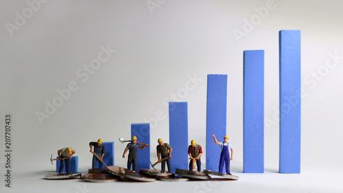 The miniature workers standing on a blue bar graph. Minimum wage increase concept. photo