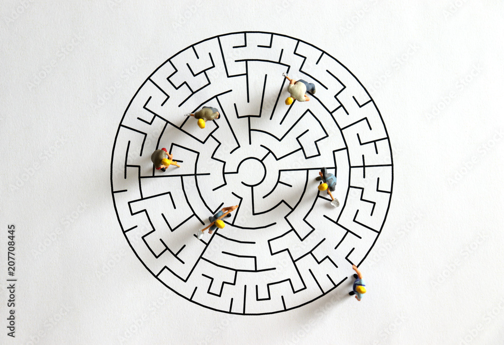 A scene of maze and miniature workers on the white background looking up from above. A scene of maze and miniature workers on the white background looking up from above.