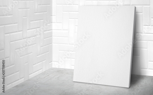 Blank poster at corner studio room with white tile wall and concrete floor background,Mock up studio room for display or montage of product for advertising on media,Business presentation.