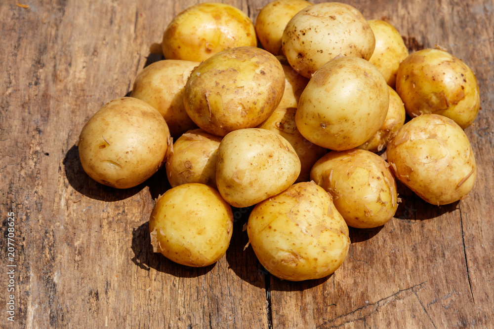 New potatoes on rustic wooden table New potatoes on rustic wooden table