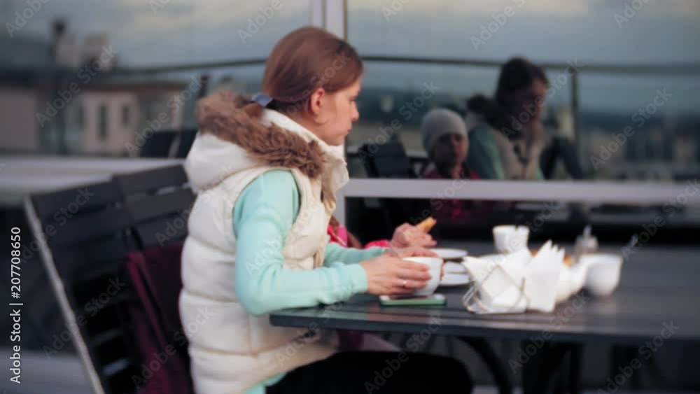 Mother and daughter eat and drink in cafe outside Mother and daughter eat and drink in cafe outside