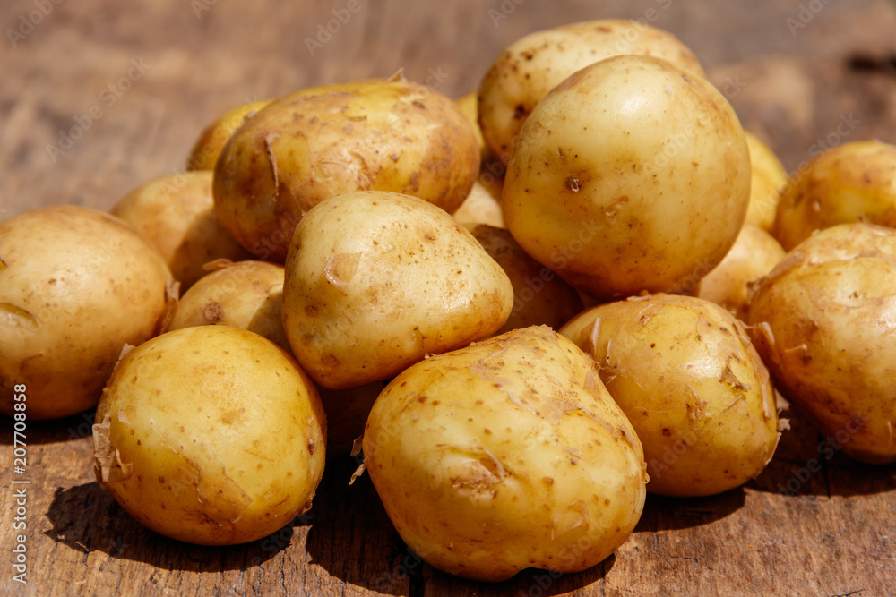 New potatoes on rustic wooden table New potatoes on rustic wooden table