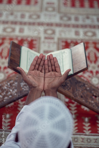 Top viewv of African Muslim Man Making Traditional Prayer To God While Wearing A Traditional Cap Dishdasha photo