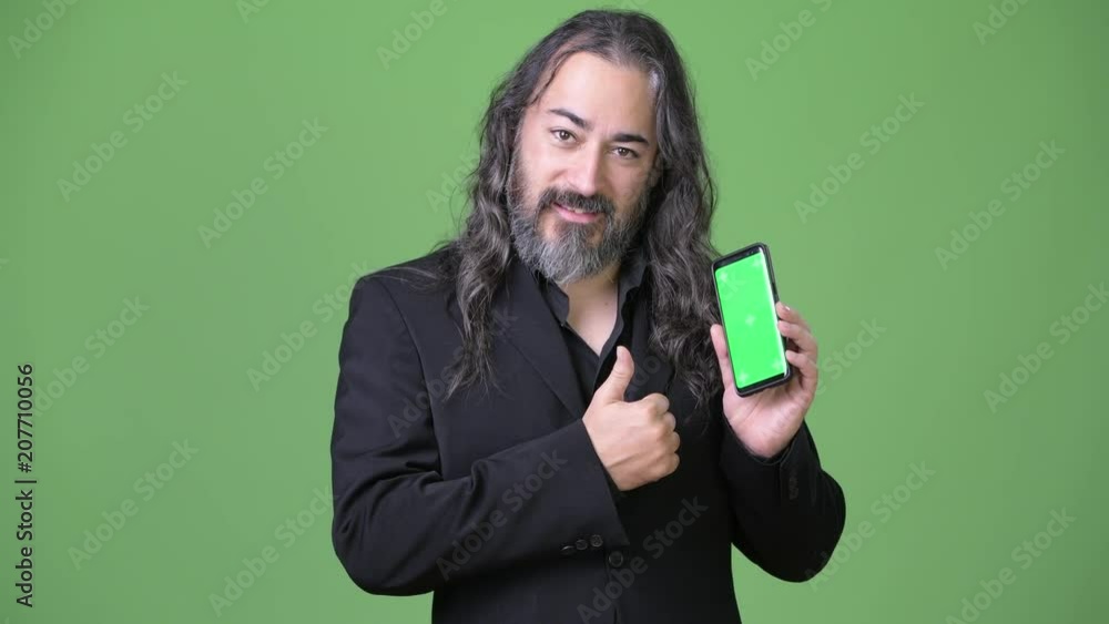 Studio shot of mature handsome bearded multi-ethnic businessman with long hair Studio shot of mature handsome bearded multi-ethnic businessman with long hair