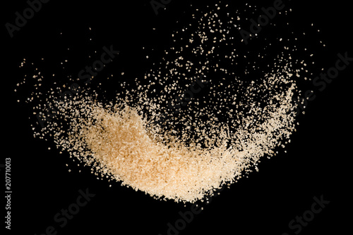 Schilderij op canvas Brown sugar flying explosion splash isolated on black background  ,throwing free