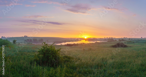 sunrise over a lake surrounded by meadows and fields © Mike Mareen