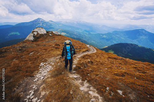 A tourist walks along a mountain meandering trail