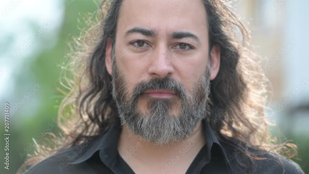 Mature handsome bearded multi-ethnic businessman with long hair in the streets outdoors Mature handsome bearded multi-ethnic businessman with long hair in the streets outdoors