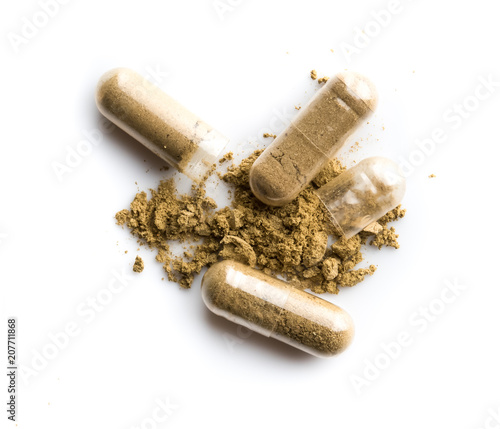 Herbal medicine powder in capsule on white background photo