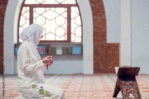 Young beautiful Muslim Woman Praying In Mosque