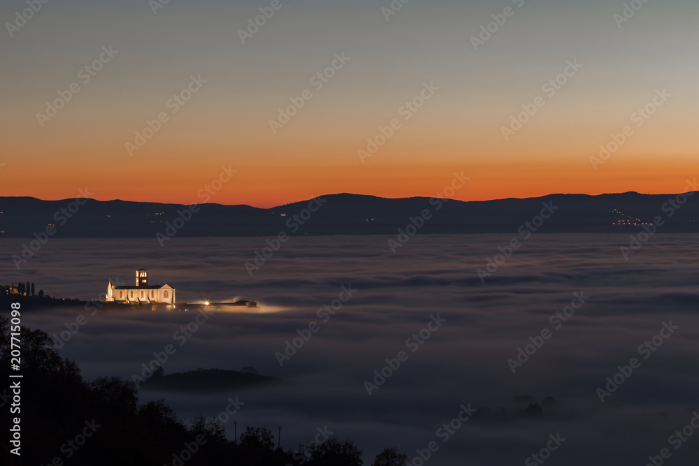 View of St.Francis church (Assisi, Umbria) at dusk, over a sea o