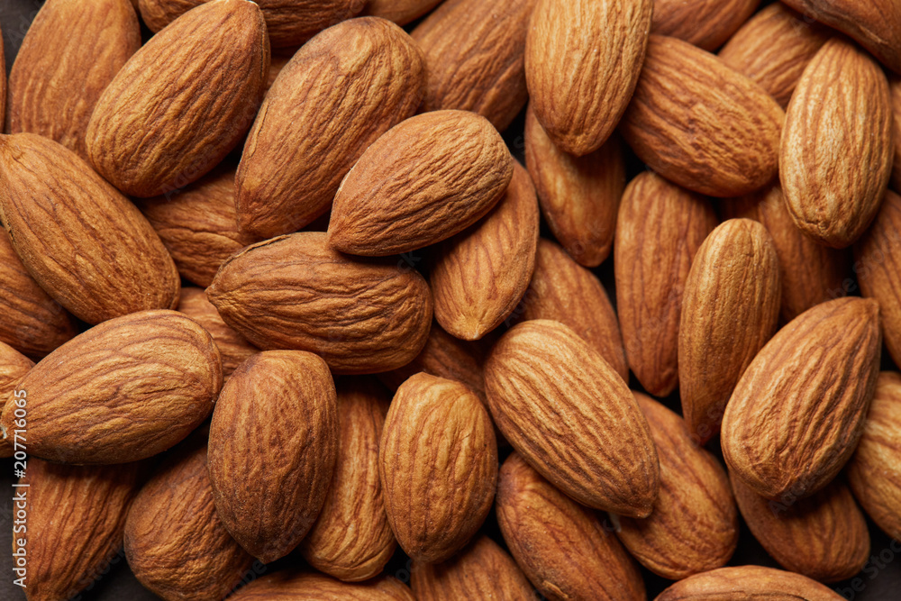 Pile of almonds close-up as background. Pile of almonds close-up as background.