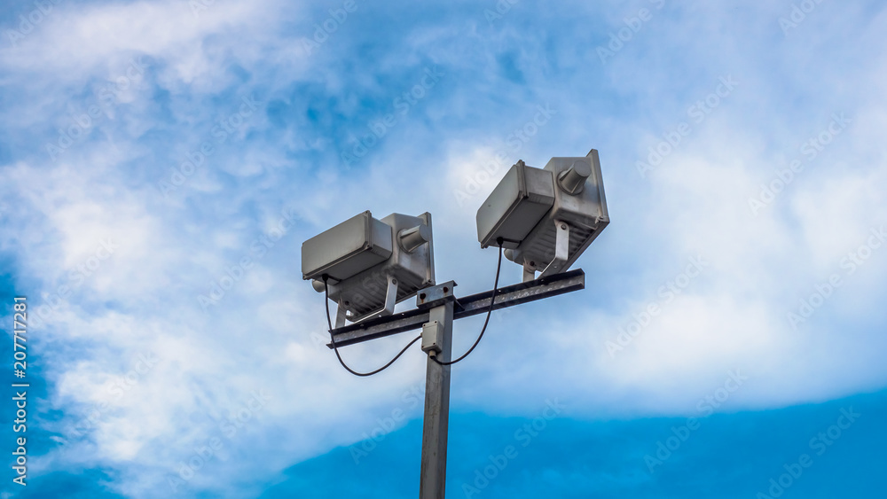 Electric Spotlight Pole on Beautiful Blue Sky Background. Electric Spotlight Pole on Beautiful Blue Sky Background.