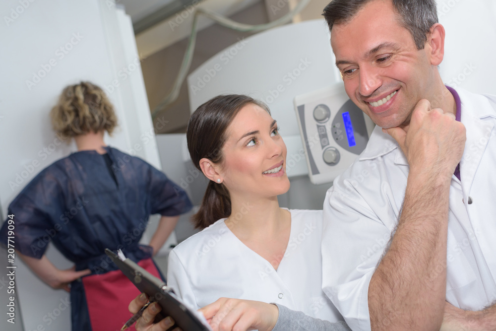 cheerful male doctor and assistant holding digital tablet while laughing cheerful male doctor and assistant holding digital tablet while laughing
