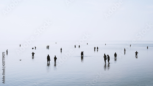 Fotografia large group of people or crowd standing walking and swimming in shallow water at