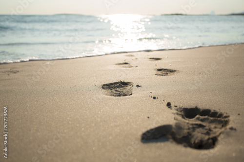 Beach. Sea. Ocean. Footprints, footsteps in the water. Sunny path on the water.