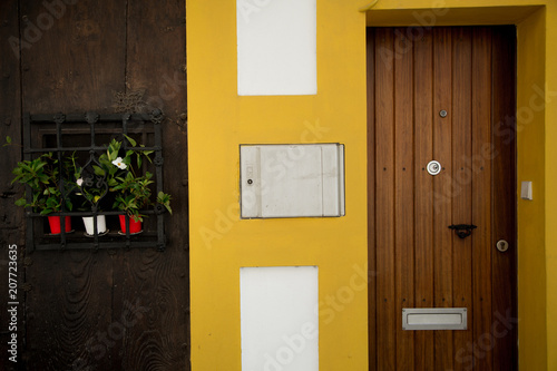  The bright yellow wall. Wooden doors. Beautiful green plants. Cozy patio.