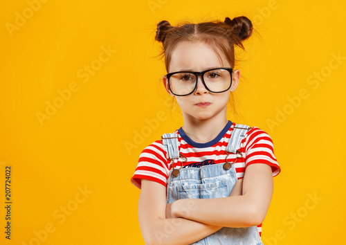 funny child girl in glasses on colored background