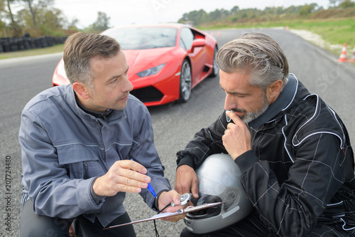 male coach and pilot discussing performance during tests with lamborghini photo