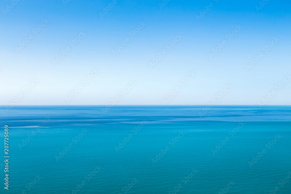 Beautiful blue unearthly seascape with clear sky and unusual stripes on the surface of the water