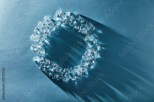 Creative round frame of ice cubes on a blue background. Flat lay