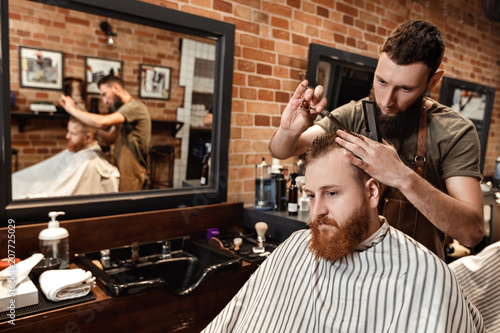 Barber and bearded man in barber shop