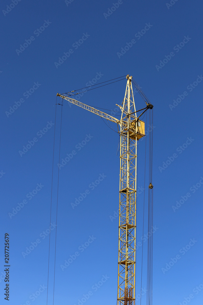 Construction crane against the blue sky.