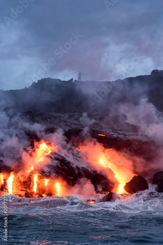 Molten lava flowing into the Pacific Ocean on Big Island of Hawaii at sunrise