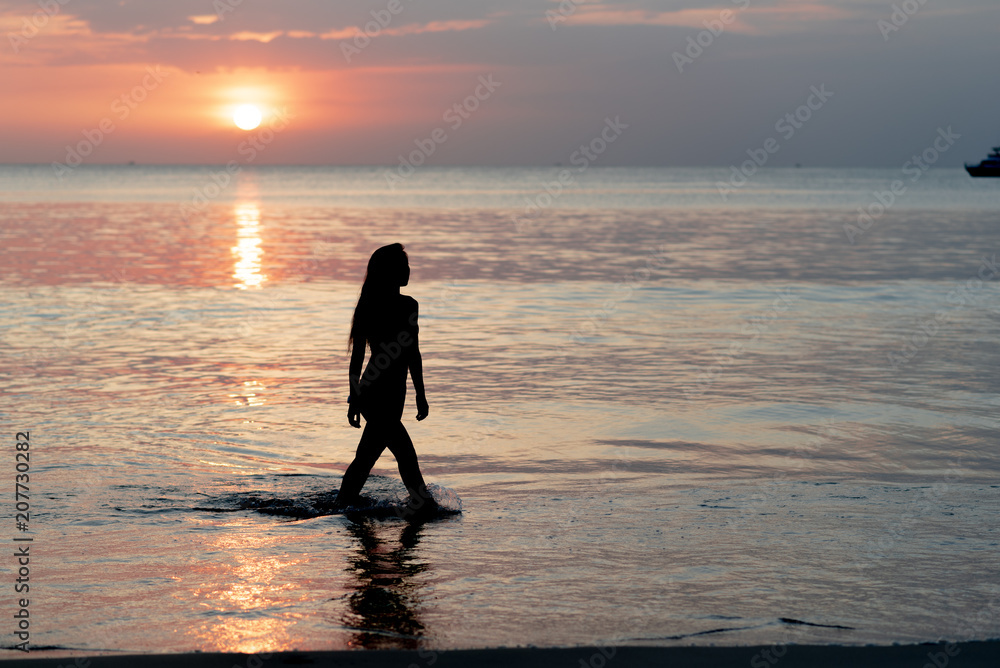 Attractive sexy women walking on the beach during sunset time