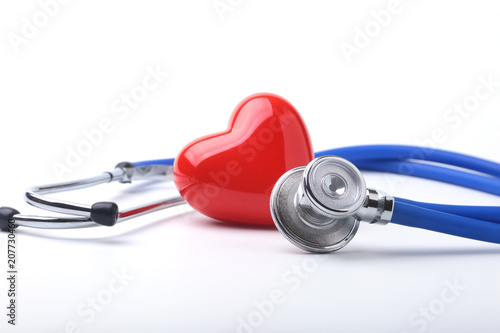Medical stethoscope and red heart isolated on white.