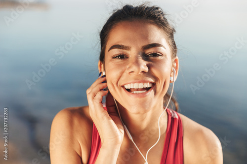 Close up of a happy sportswoman listening to music