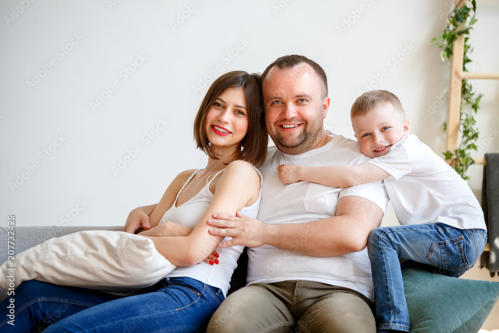Picture of cuddling parents with son sitting on sofa Picture of cuddling parents with son sitting on sofa