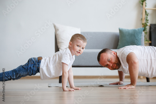 Image of happy dad and son pushing on floor