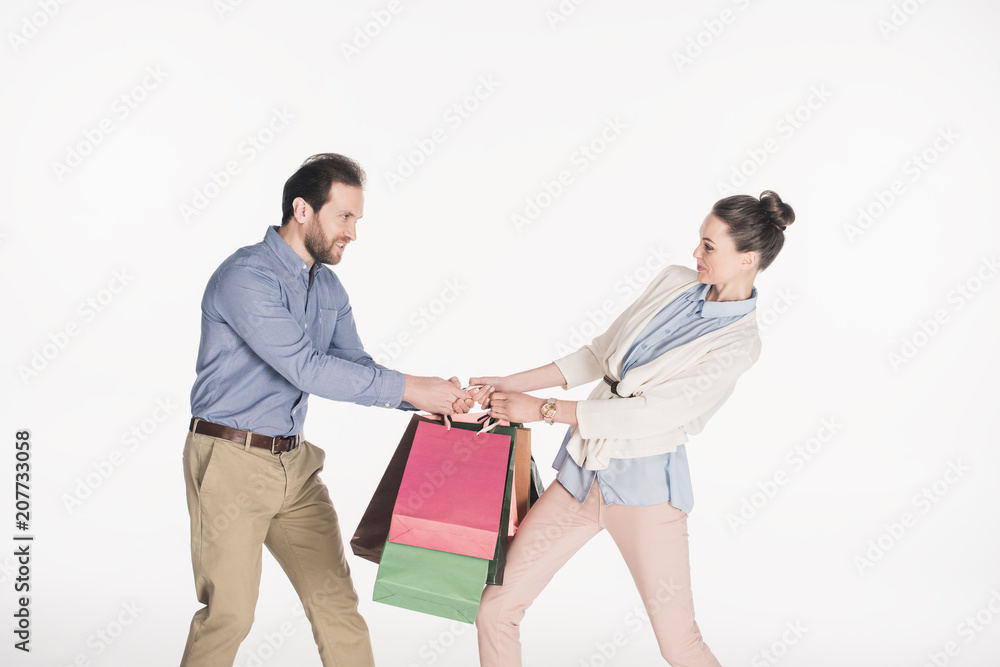 side view of couple pulling over shopping bags isolated on white side view of couple pulling over shopping bags isolated on white