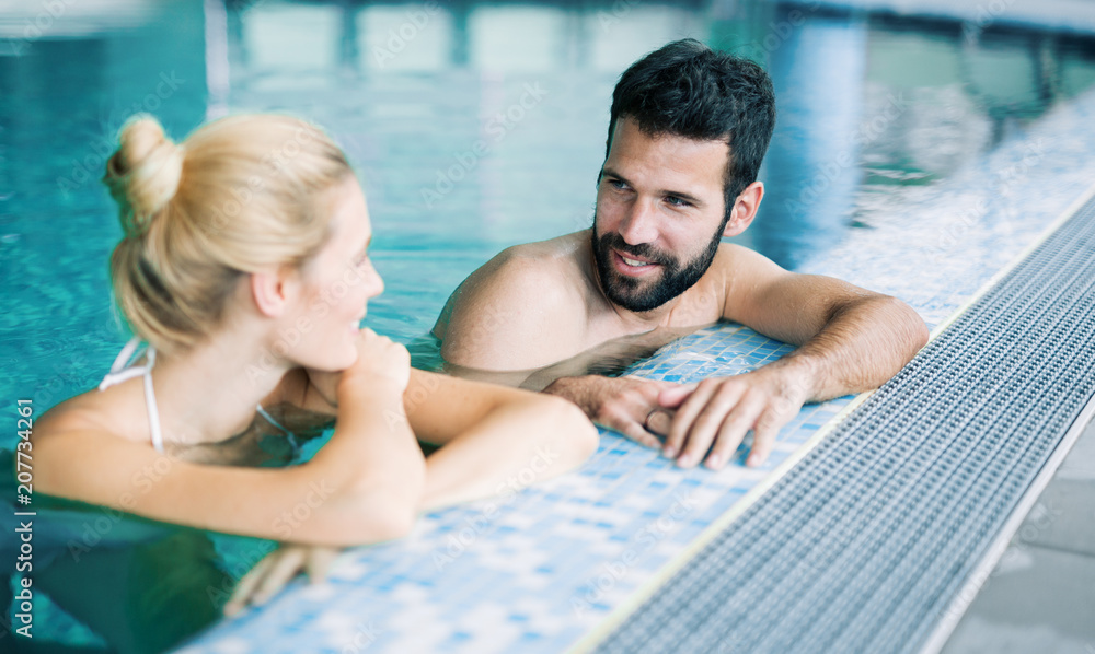 Fototapeta premium Happy attractive couple relaxing in swimming pool