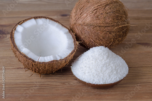 coconut flakes in a bowl on wooden background