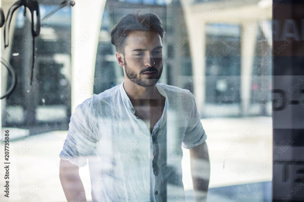 Fototapeta premium One handsome young man in urban setting in European city